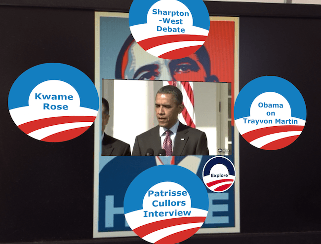 An AR remix of Fairey’s Obama Hope poster. An image of the president giving a speech at the White House has been superimposed onto the center of the image. Four digital
          buttons encircle the image stylized as remixed versions of Obama’s original campaign logo.