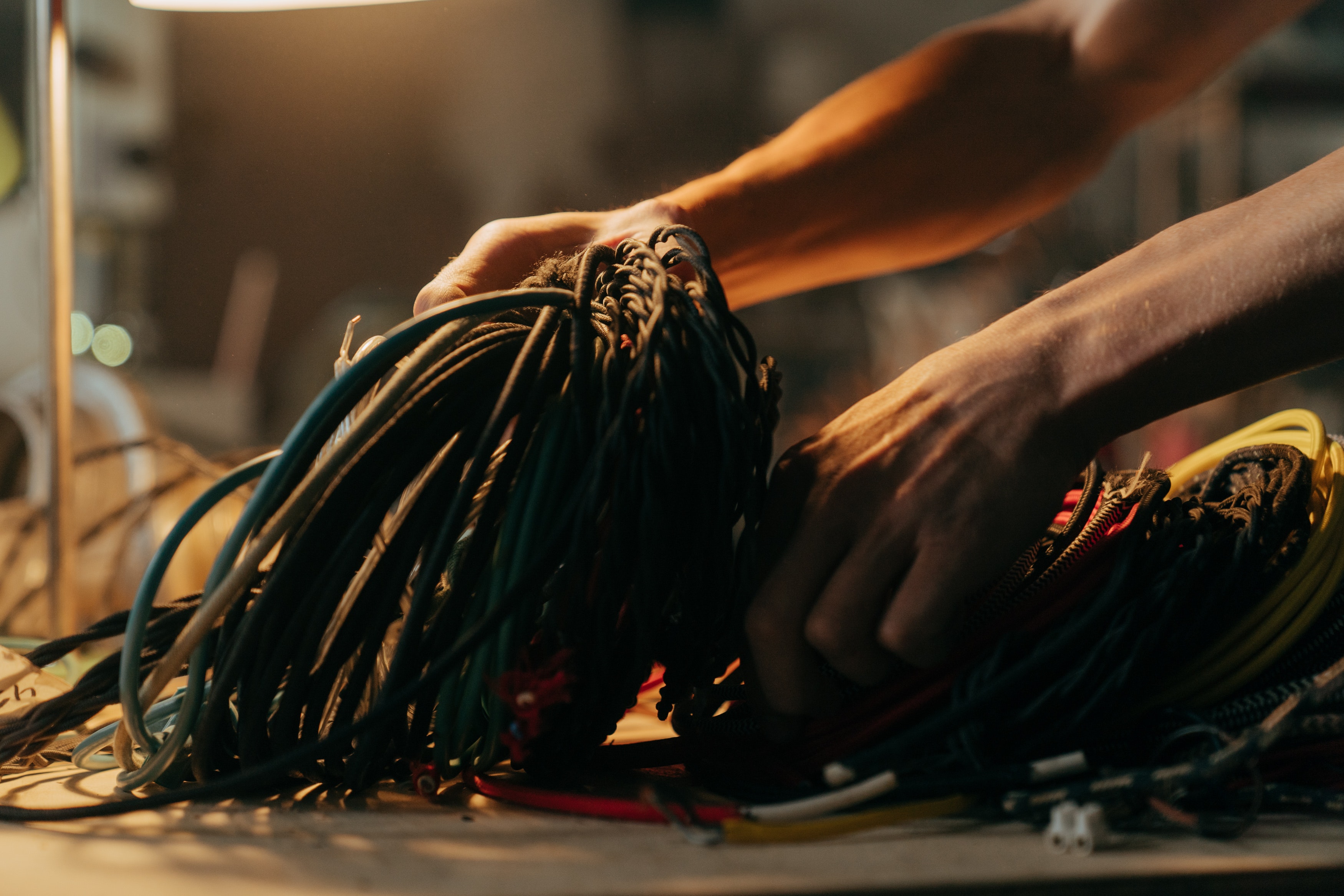 A hand holding a pile of wires. Photo by Cottonbro Studio.