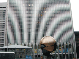 A building with a spherical sculpture in front