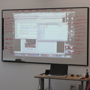 A computer is being projected on a white board type surface. 