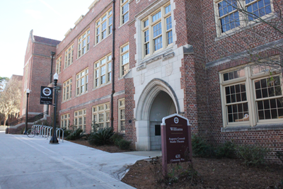 The Williams Building at FSU is a three story, historical building with large, pane glass windows, brick exterior walls, and an arch entrance. 