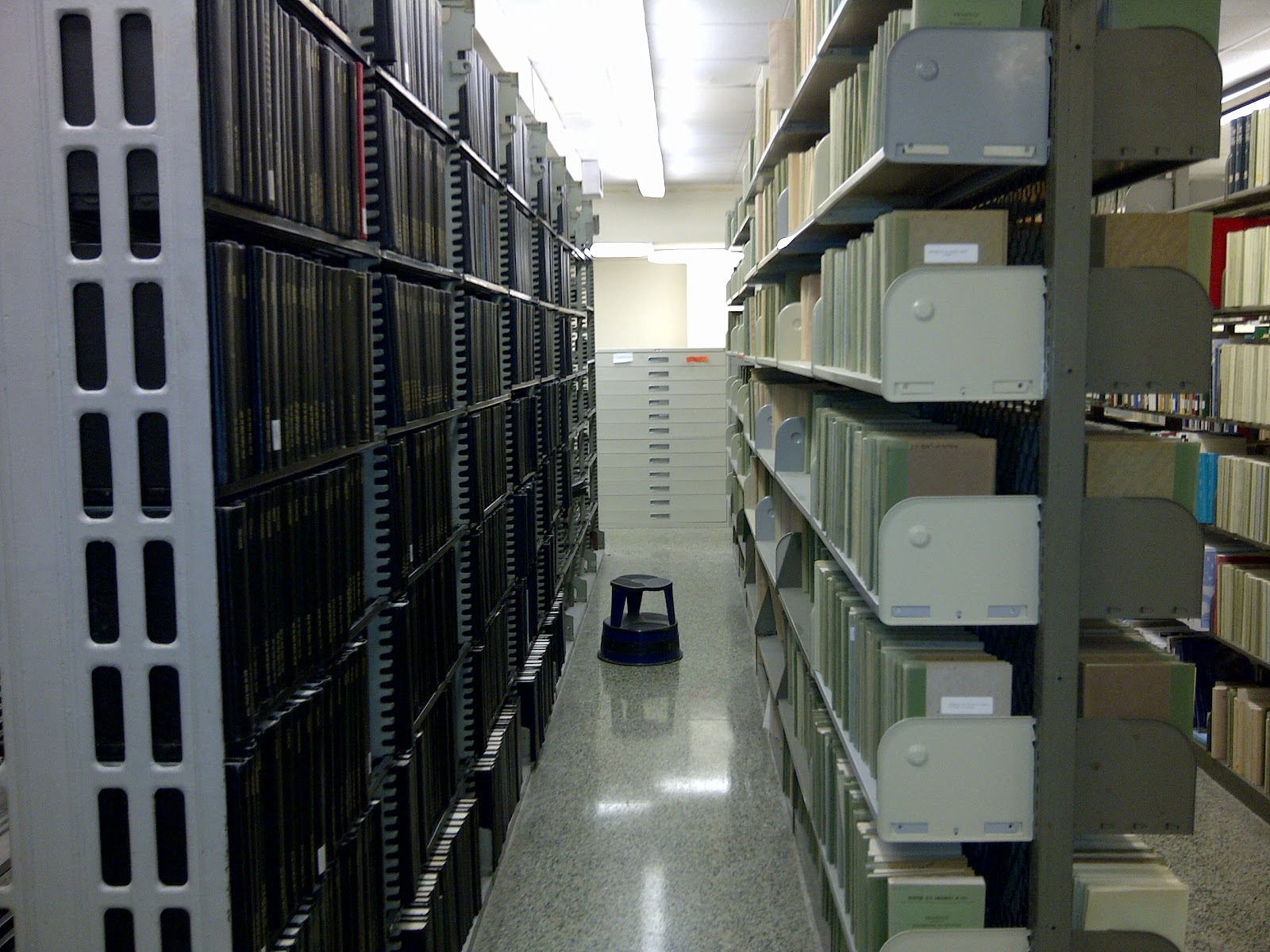 An aisle of a library bookshelves with books.