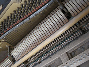 View of the inside of Jackie's upright piano; felt keys and strings.