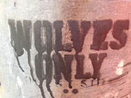 Graffiti: WOLVES ONLY written in dripping black paint.