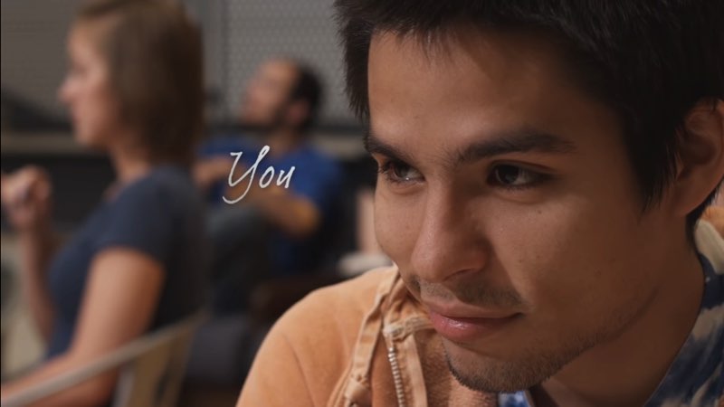 A male student is smiling confidently as a handwritten word appears next to his eyes: “You.”