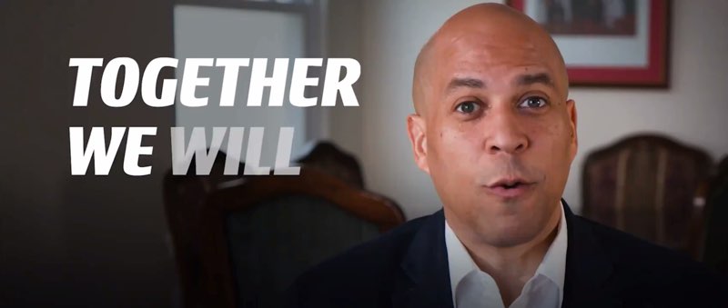 The screenshot of Booker's video now shows facing the camera directly. Open captions appear: "TOGETHER WE WILL," with “WILL” about to appear in full on screen.