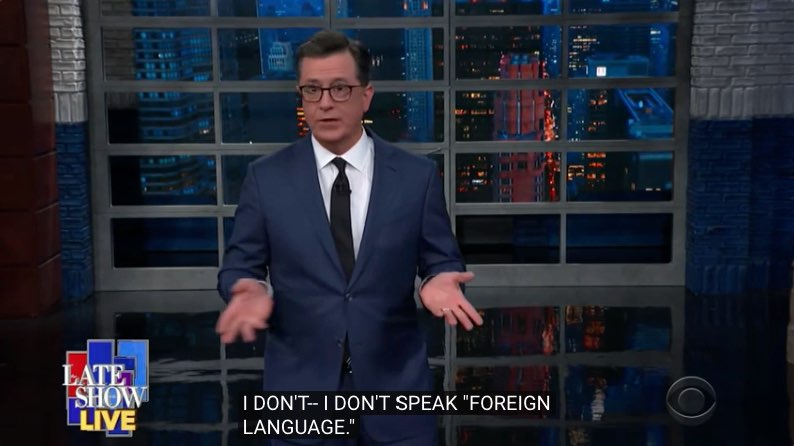 Colbert has his hands out in front of him. Closed captions at the bottom of the screen read, "I don't-- I don't speak ‘foreign language.’"
