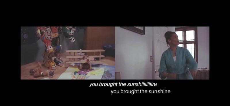 Two side-by-side images capture a moment in the video. The left image shows children's toys and children's artwork, and the right image shows a woman signing the song. There are two rows of captions at the bottom of the screen. The first row reads: "you brought the sunshiiiiiiine" in italics. The second row reads "you brought the sunshine" in regular font.