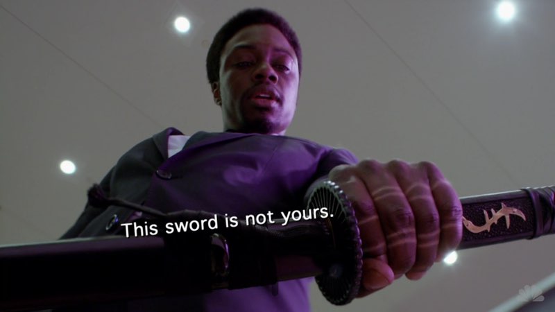 A man is holding a sword as he looks down at the ground. The subtitles, aligned diagonally along the sword, read, "This sword is not yours."