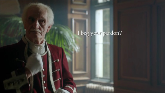 An elderly man dressed in a Victorian-era formal red uniform signs with open subtitles in the space between his sign and his eyes on the right side of the screen. The subtitles read, “I beg your pardon?”