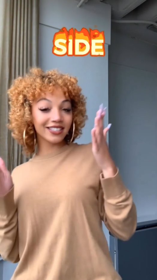 Justina Miles signs the word, "side." Above her are captions for the word "side." The word seems to be on fire.