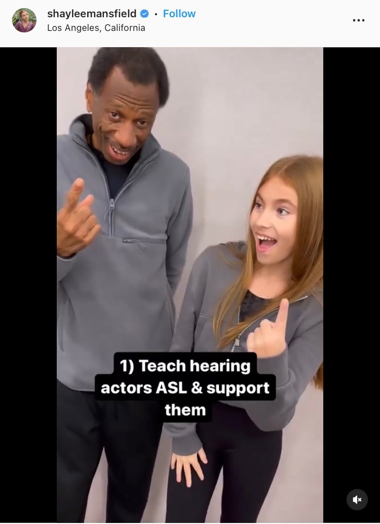 Screenshot of Shaylee Mansfield's Instagram post. Shaylee and CJ are standing next to each other and smiling open smiles. They are both signing the number one. Open subtitles appear in front of them and read, "1) Teach hearing actors ASL & support them."