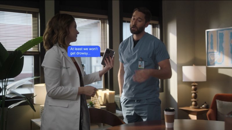 Max and Elizabeth are standing near each other in her office. She holds out a phone to him with a blue bubble between them that reads, "At least we won't get drowsy..."
