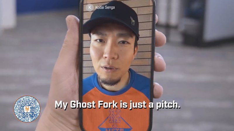 Kodai Senga is shown on a smartphone that someone is holding. He is wearing the Mets colors of blue and orange, along with a baseball cap. As he speaks, subtitles appear at the bottom reading, "My Ghost Fork is just a pitch."