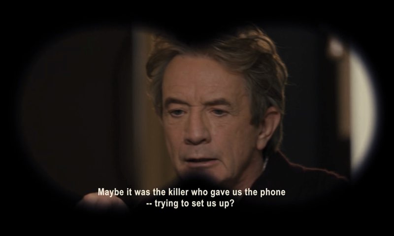 Oliver is seen through Theo's binoculars. Open captions at the bottom of the screen read, "Maybe it was the killer who gave us the phone—trying to set us up?"