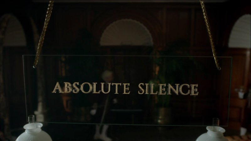 A transparent glass sign for the Diogenes Club reads “ABSOLUTE SILENCE.” Visible through the glass is the front room.