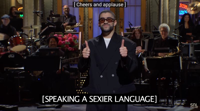 Bad Bunny, in the same scene, has thumbs up. Open subtitles at the bottom read, "[Speaking a sexier language]." Closed captions appear at the top of the screen: "[Cheers and applause]."
