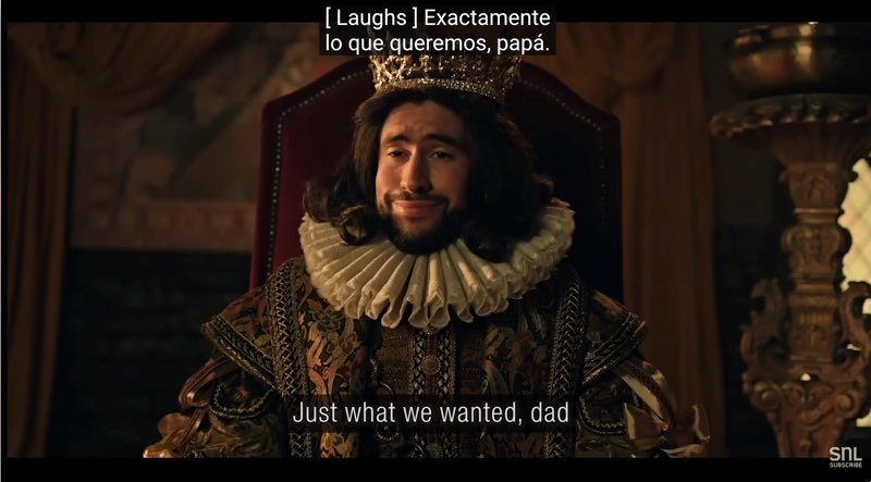 Bad Bunny is in costume as a Spanish king from the Age of Discovery. Open subtitles appear at the bottom that say, "Just what we wanted, dad." Closed captions appear in Spanish at the top that read, "[Laughs] Exactamente lo que queremos, papá."