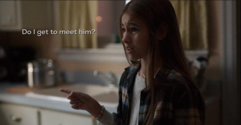 Ollie, looking concerned, is in her kitchen signing, with subtitles near her face that read, "Do I get to meet him?"